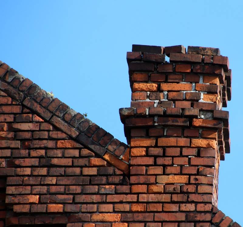 Damaged chimney on an Lake Dallas home showing cracks and missing mortar